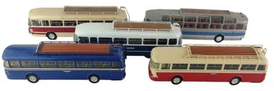 quatre petits bus qui sont rangés les uns à côté des autres