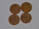 three gold coins sitting next to each other on a white surface