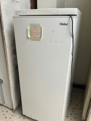 un réfrigérateur blanc sur lequel est collé un autocollant, dans une cuisine
