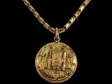 un collier en or avec une pièce de monnaie sur une chaîne