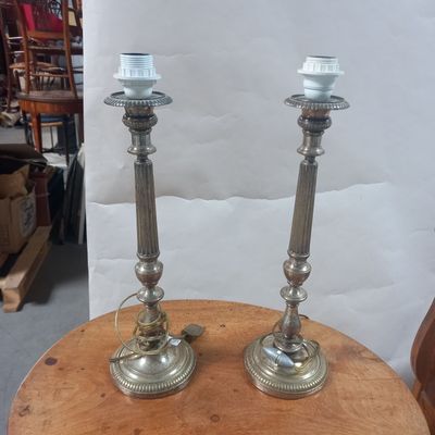 une paire de bougies en argent posées sur une table en bois