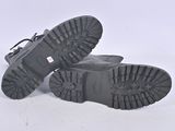 pair of black boots on a white surface with a white background