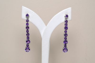 purple amethorate earrings on display on a white stand