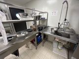 une cuisine équipée d'un évier, d'une cuisinière et d'autres éléments