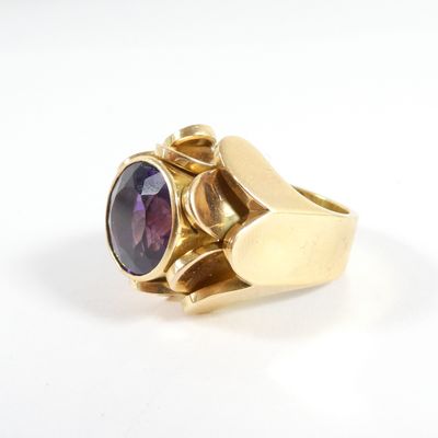 une image d'une bague en or avec une pierre violette au centre