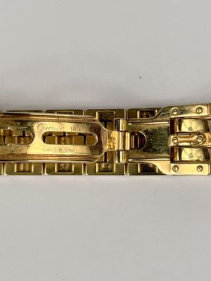 a close up of a gold bracelet on a white surface