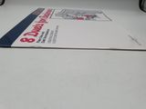 a white table with a book on it and a pair of glasses on the table