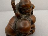 une petite statue représentant un homme assis sur une boule