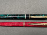 two pens sitting next to each other on a table
