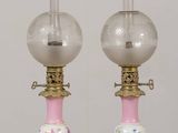 pair of pink glass lamps with gold trims on a wooden table