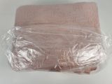 a pink towel wrapped in plastic on top of a white table