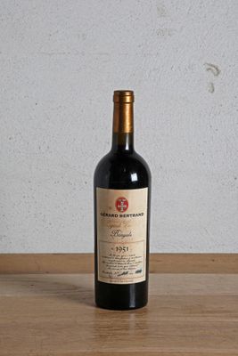 a bottle of red wine sitting on a wooden table