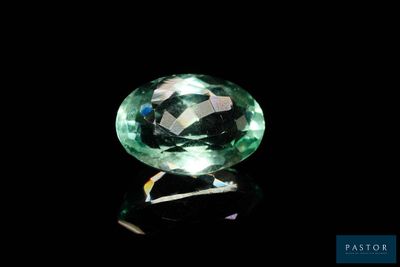 a close up of a green gemstone on a black surface