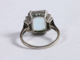 an image of a ring with a turquoise stone surrounded by diamonds