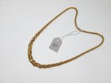 une photo d'un collier à chaîne dorée muni d'une étiquette