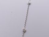 a close up of a silver necklace with a diamond on a chain
