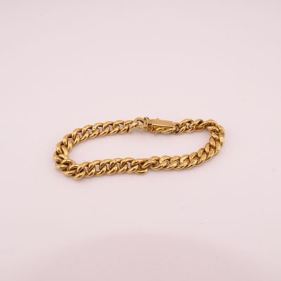 un bracelet en chaîne en or sur fond blanc