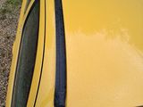 a yellow car parked next to a bike on the side of the road