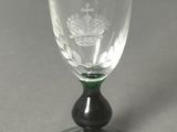 a wine glass with a green base on a table