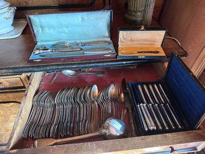 une valise posée sur une table, contenant de l'argenterie