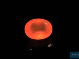 une pierre orange vif sur une surface noire