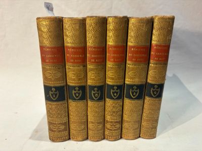cinq vieux livres sont alignés sur une surface blanche