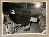 photographie en noir et blanc d'un homme assis sur une chaise dans un théâtre