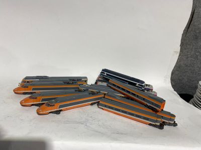 une pile d'agrafeuses orange et noires posées sur une surface blanche