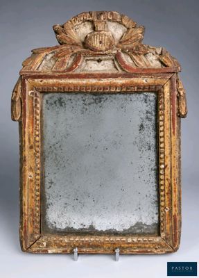 un miroir ancien avec un cadre doré sur lequel est représenté un visage
