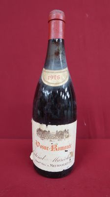 bottle of red wine sitting on a red surface with a red background