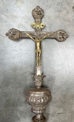 une croix posée sur un socle, sur laquelle est fixé un crucifix