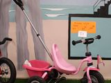 a pink tricycle and a pink tricycle in a room