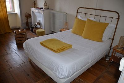 un lit blanc orné d'oreillers jaunes, dans une chambre