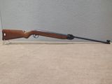 a rifle on a table next to a wall
