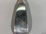 a silver spoon with a silver handle sitting on a table