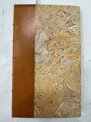 un gros plan sur un livre marron et beige à la couverture en cuir