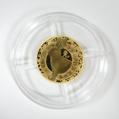 une pièce d'or représentant un cheval, posée sur une assiette transparente