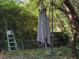 un parapluie accroché à un arbre dans le jardin