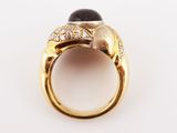 a gold ring with a black stone and white diamonds