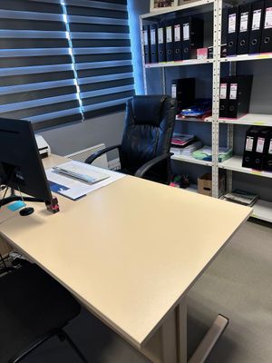 un bureau avec un ordinateur et une chaise dans une pièce