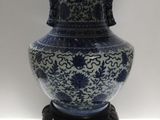 un vase bleu et blanc posé sur un socle