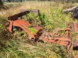 a rusted out car sitting in the middle of a field