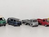 several toy trucks are lined up in a row on a white surface