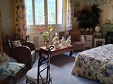 une chambre avec un lit, des chaises, une table et un lustre