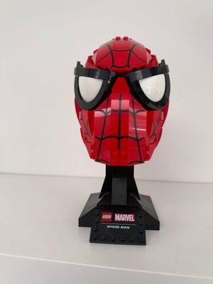 un gros plan d'un masque de Spider-Man rouge sur une surface blanche