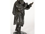 une statue en bronze représentant un homme tenant un oiseau dans la main