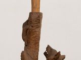 a wooden sculpture of a bear holding a tree branch
