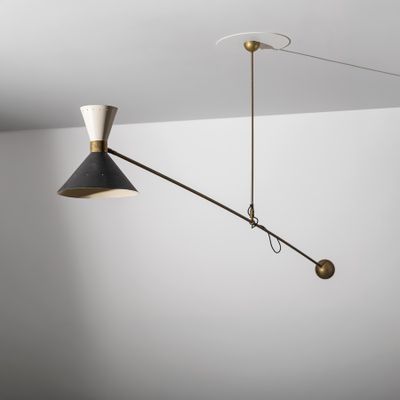 une lampe noire et dorée suspendue au plafond dans une pièce