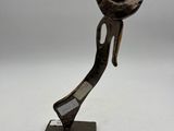 an image of a metal sculpture of a person holding a flower