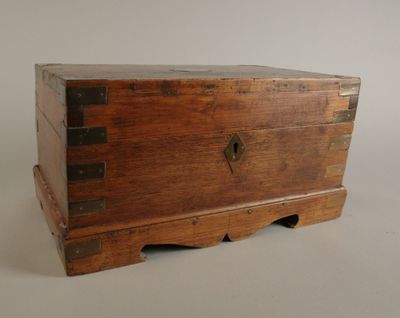 une petite boîte en bois munie de poignées en métal, posée sur une table